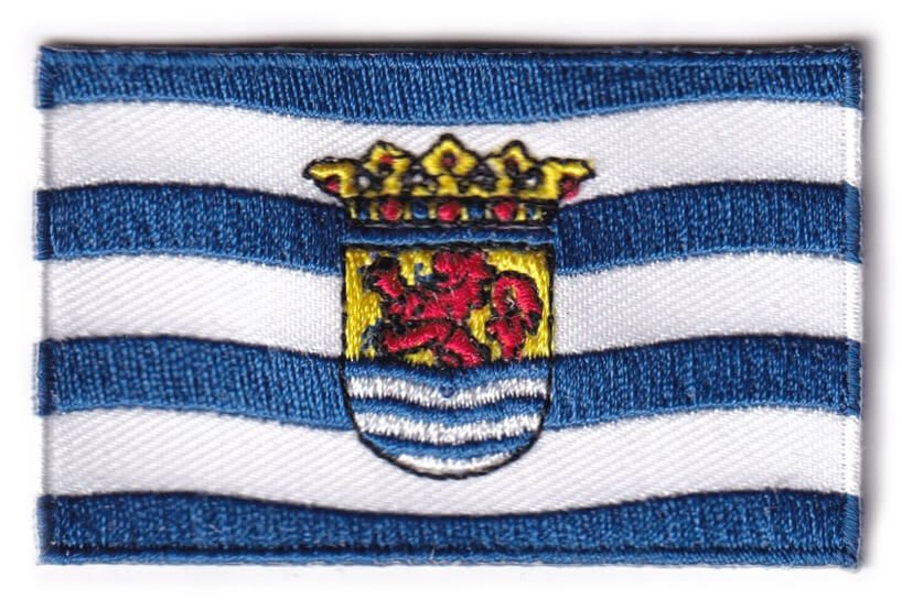 Zeeland flag patch with coat of arms and blue wavy lines, measuring 6.5 x 4 cm.