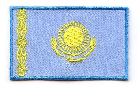 Kazakhstan flag patch with golden sun, eagle, and webbed pattern on light blue background.