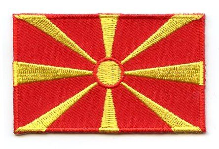 North Macedonia flag patch featuring yellow sun with eight rays on red background.