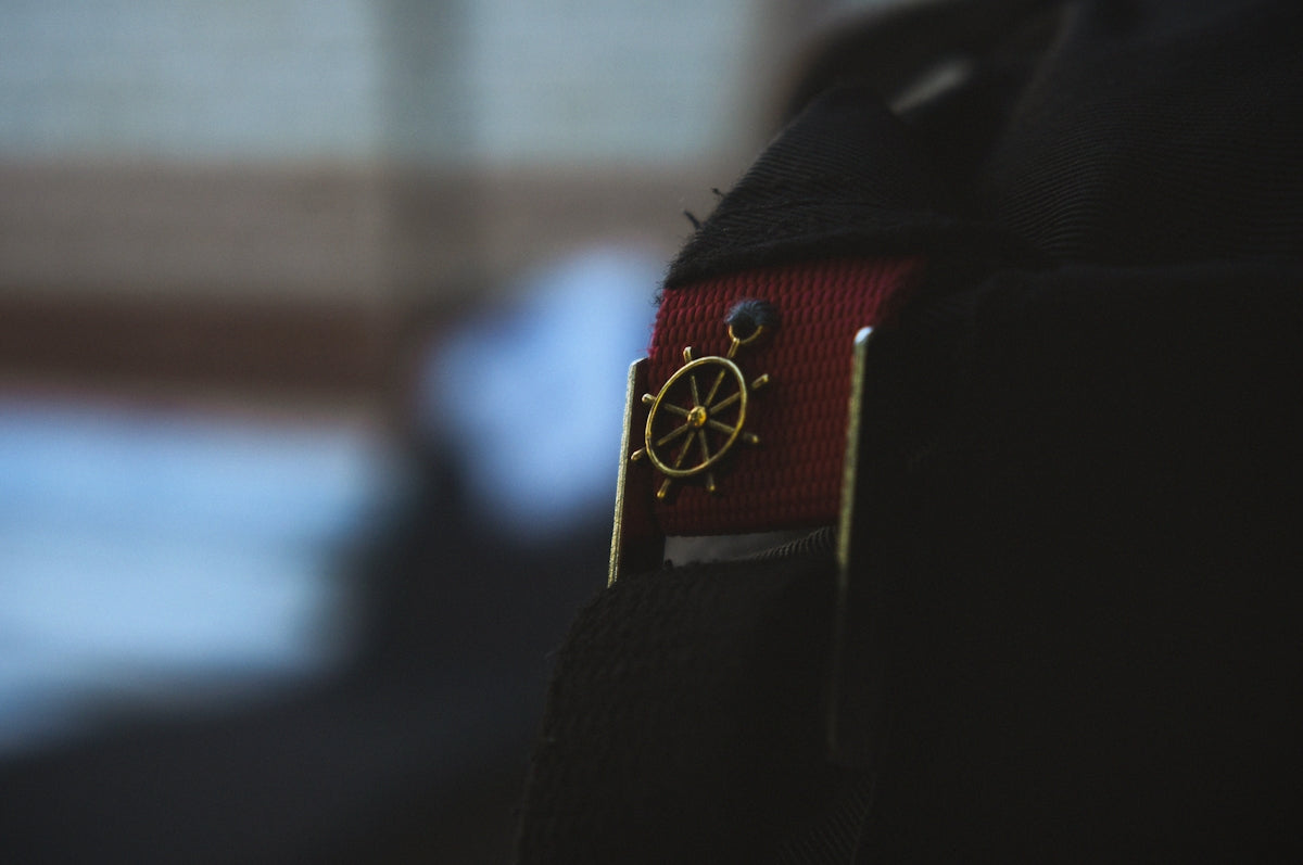 A close up of a black jacket with a red belt